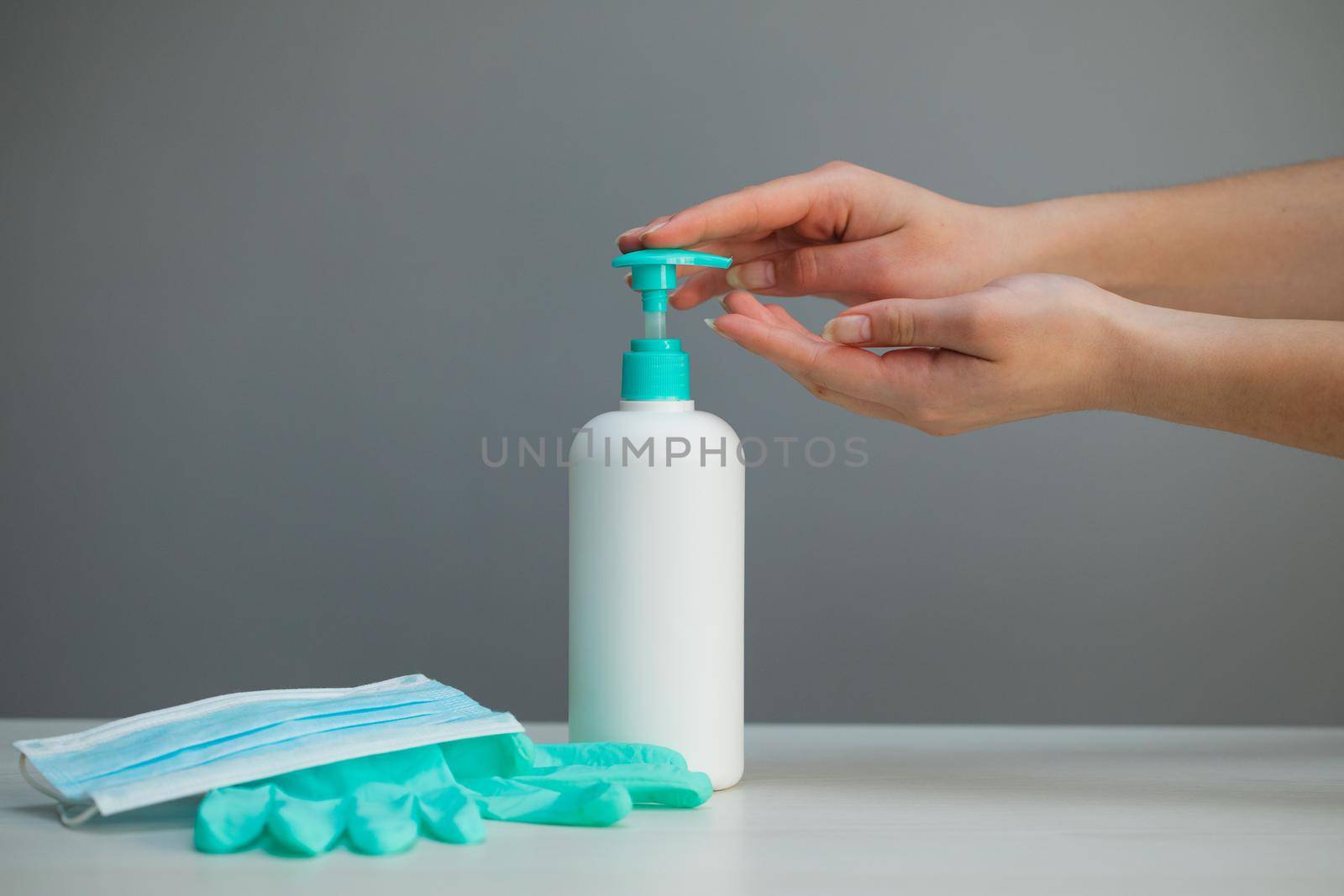 Hand sanitizer alcohol gel rub clean hands hygiene prevention of coronavirus virus outbreak. Woman using bottle of antibacterial sanitiser soap. Travel surgical masks and hand sanitizer gel. by uflypro