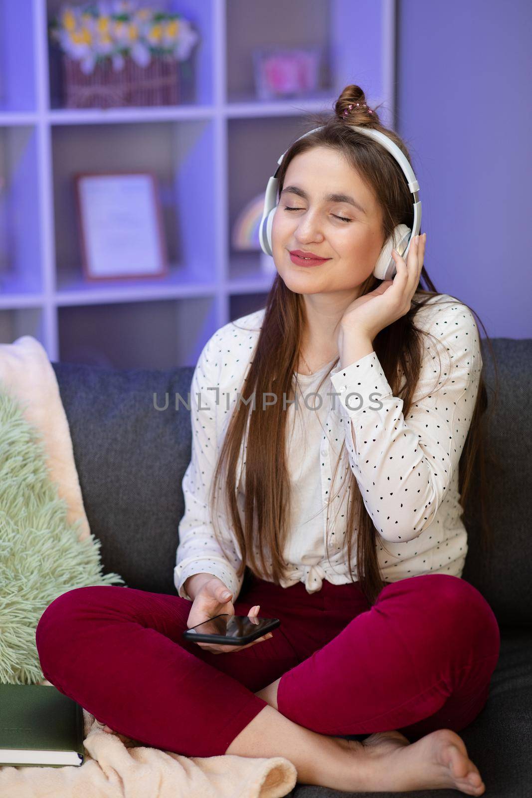 Woman listening music in headphones in room. by uflypro