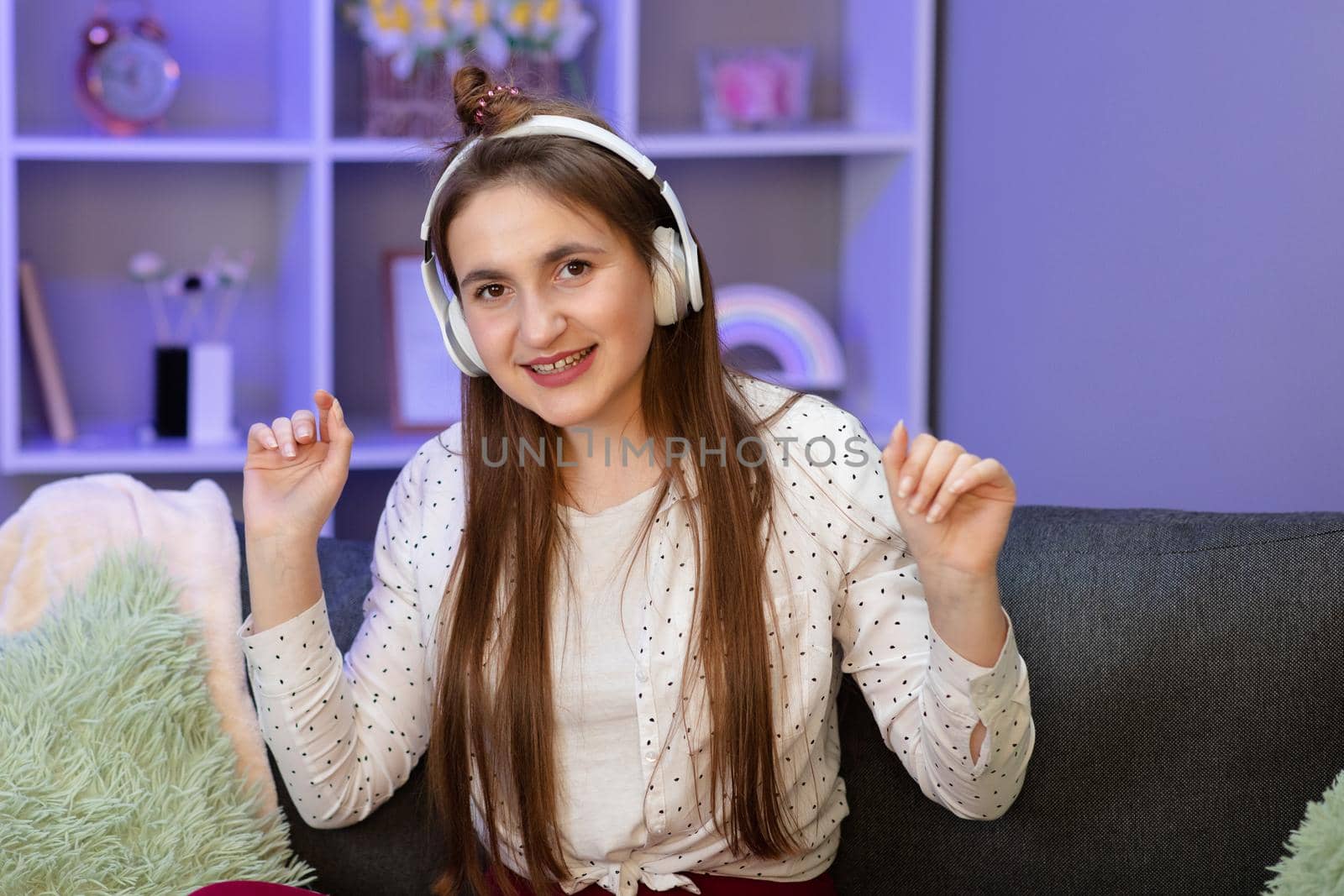 Woman in bright outfit enjoying the music at home. by uflypro