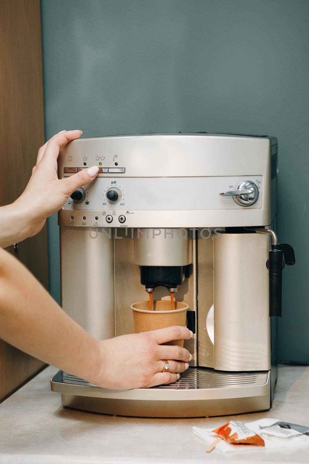 Close-up of a barista woman's hand making coffee by the coffee machine. Close-up view of woman's hands brewing a cup of coffee