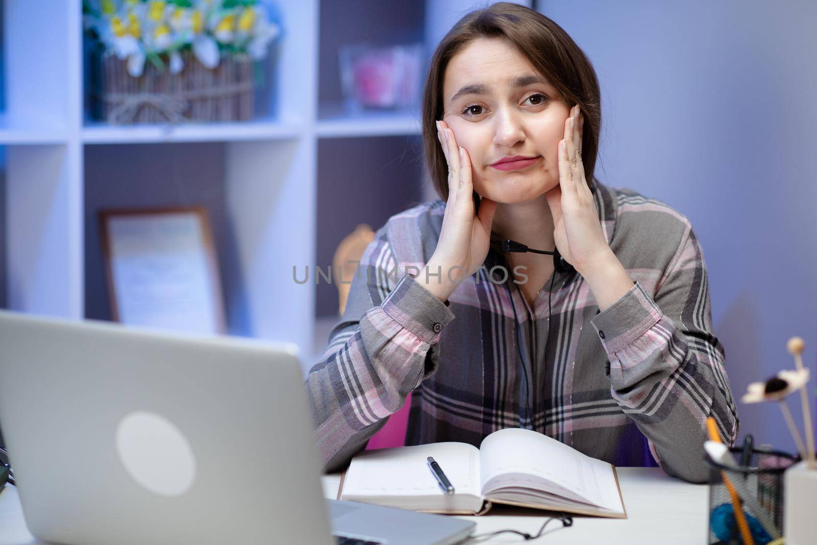 Cute girl looking and overwhelmed sitting at the desk at home doing homework. Stress emotions surprised expressive studying learning home by uflypro