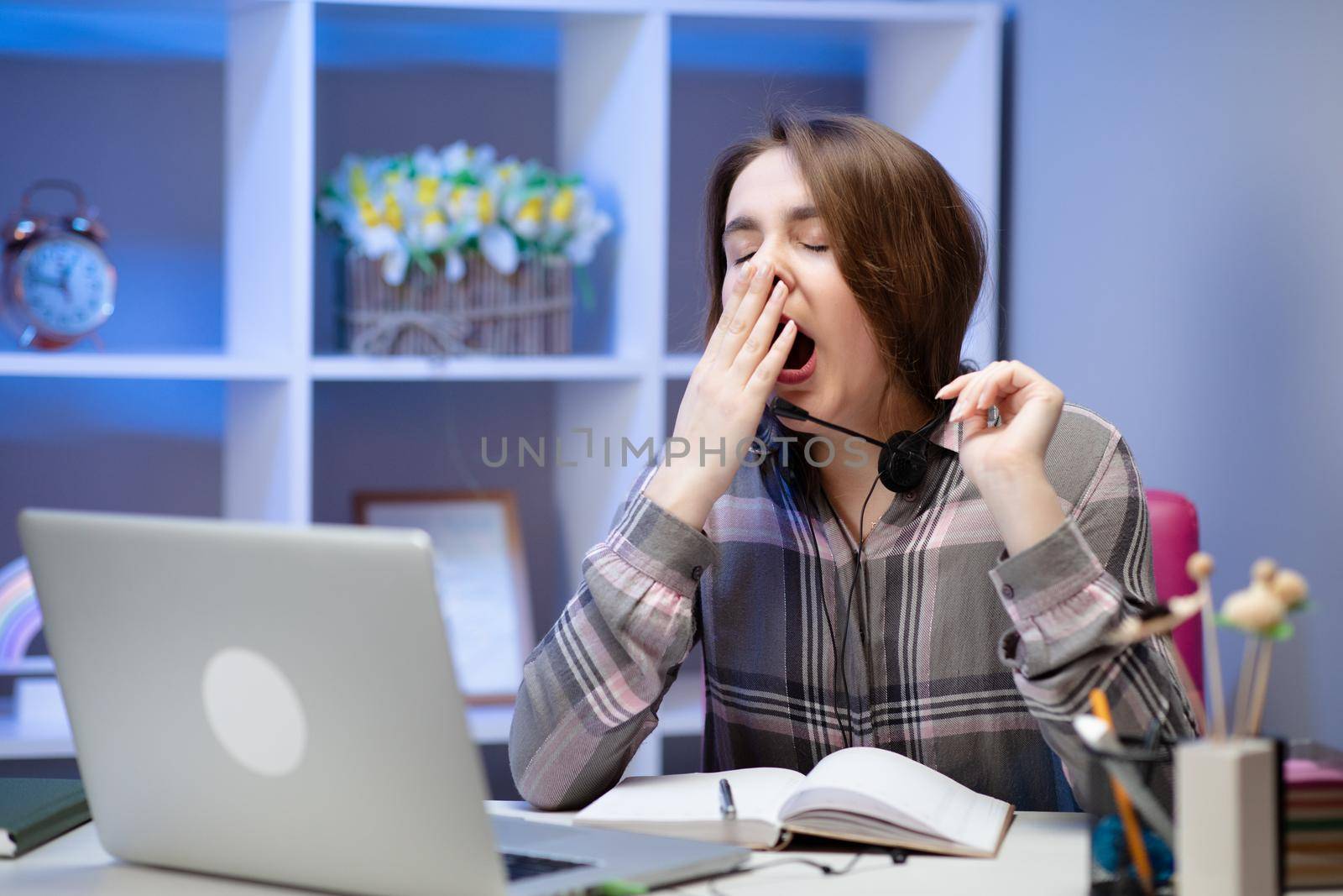 Tired woman yawning, sitting at table with laptop, lazy student doing homework, preparing to pass exam, sleepy girl working on computer after sleepless night, lack of sleep and boredom concept by uflypro