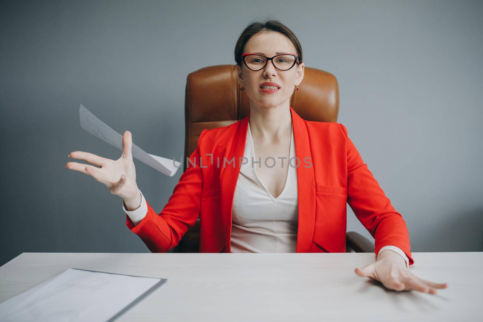 Young stressed woman sitting at desk in a little office or home mad at work. Portrait of tired young business woman. by uflypro