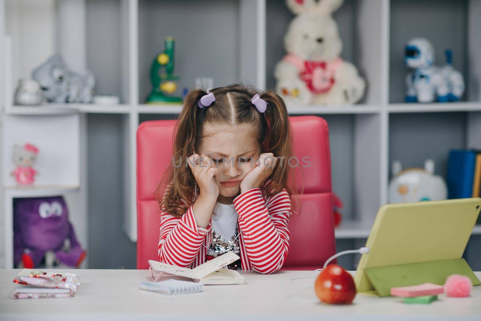 Girl video call online via the internet tutor on the tablet, child is study and greeting good morning teacher while sitting in the living room at home