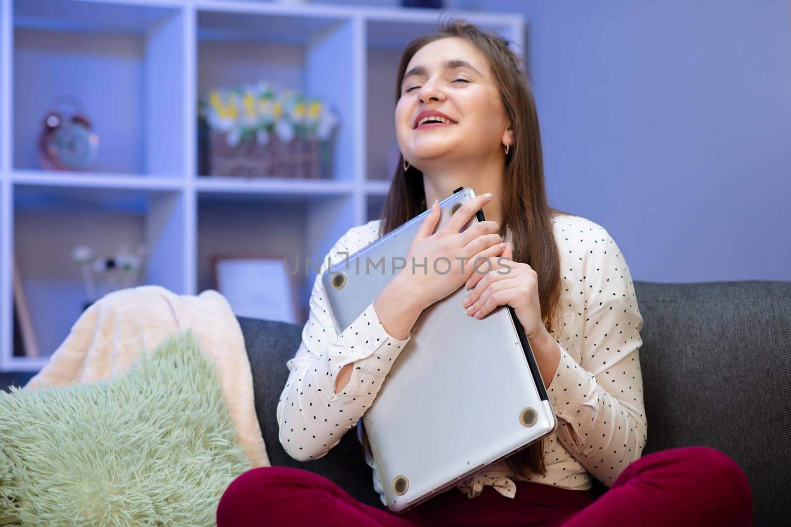 Brunette woman hug laptop computer, she love her work. Happy young girl,student hugging book, notebook, love studying, reading, finished homework. Sitting in her room at table with laptop.