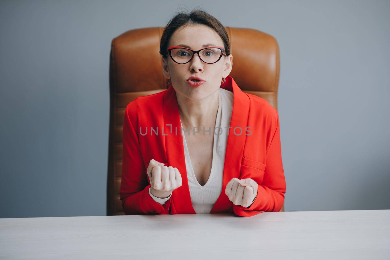 Angry girl at workplace. Upset business woman. Depressed businesswoman blogger vlogger influencer sit at home speaking looking at camera talking make video chat by uflypro