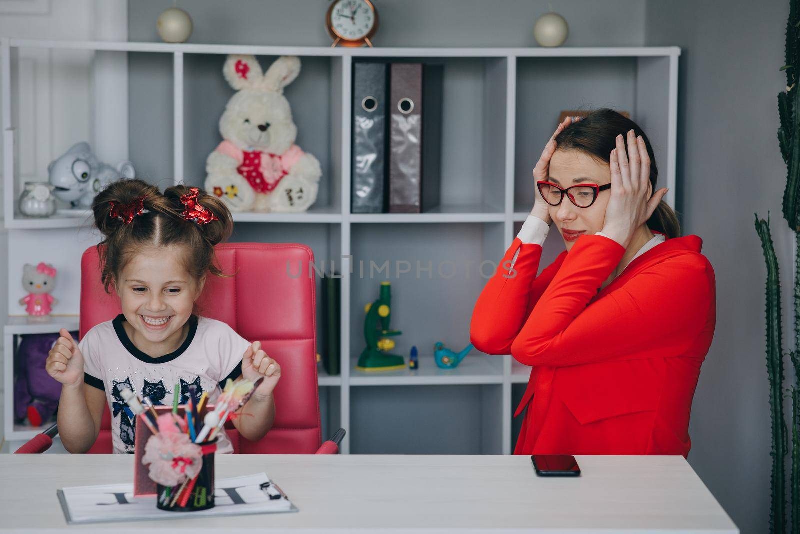 Small child practicing articulation with therapist at private lesson at home.