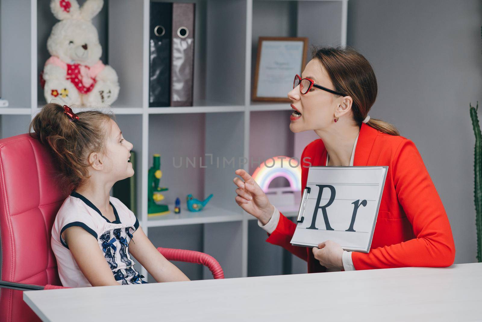 Voice Ability Problem Speaking Lesson Concept. Speech therapist teaches the girls to say the letter R. Female Speech Language Therapist Teaching Preschool Kid Sound Pronunciation.
