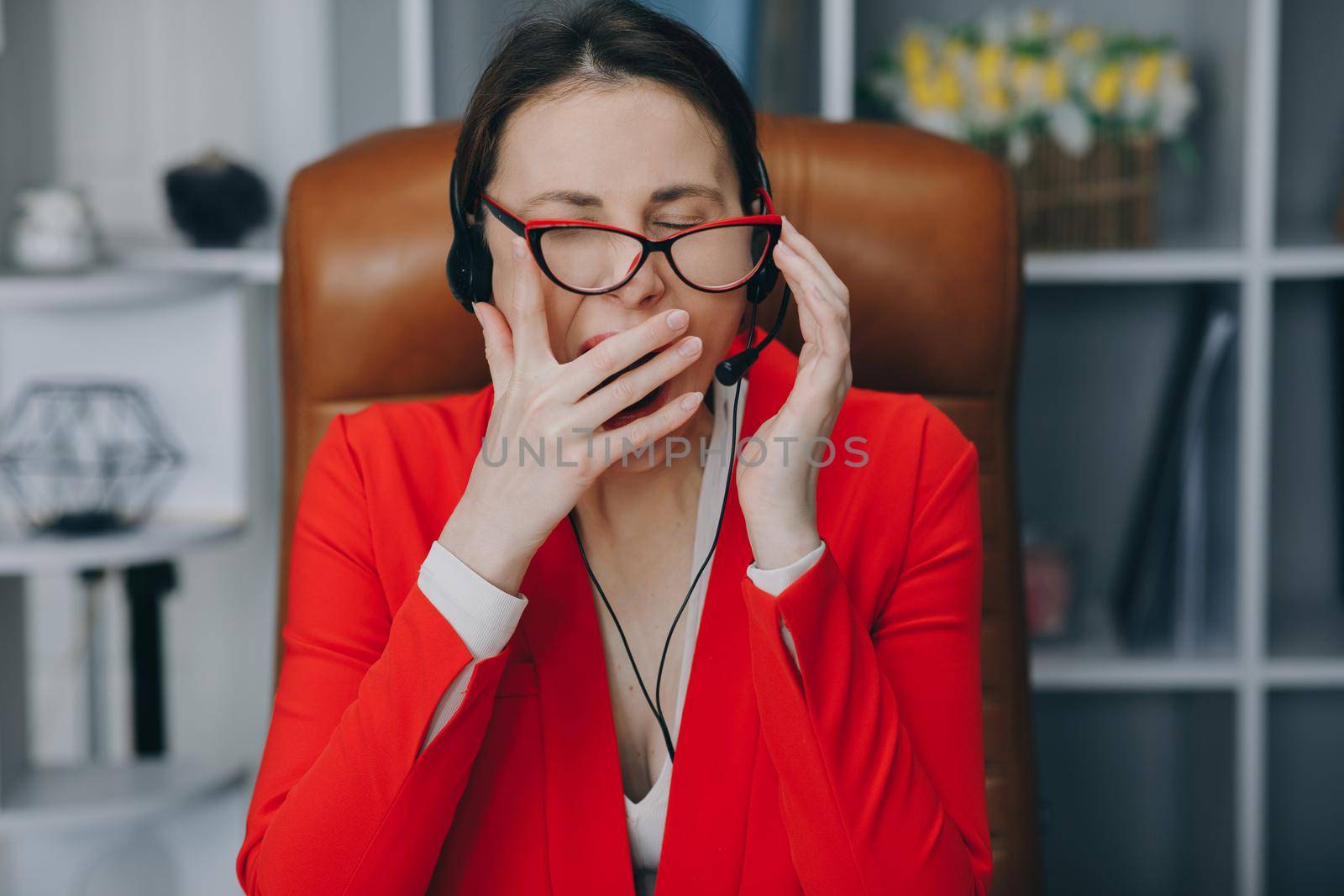 Call center operator is tired of talking to people asking stupid questions. Young customer service representative at work. Young female worker productively operating at call-centre.