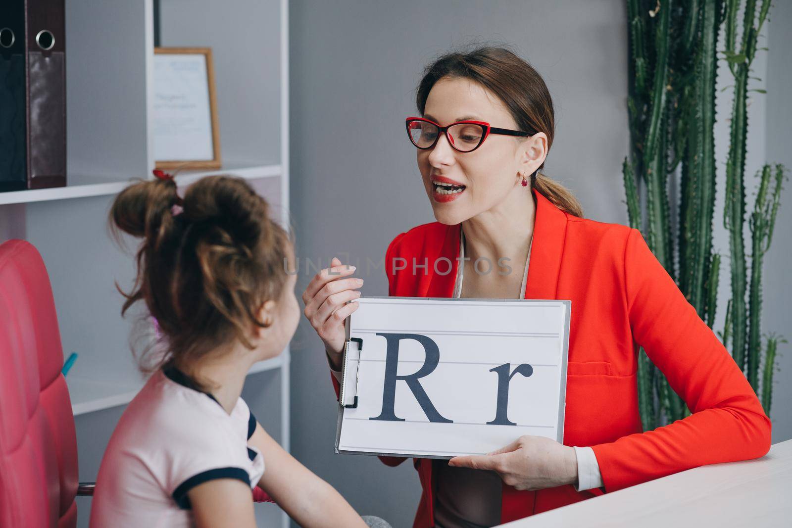 Speech therapist teaches the girls to say the letter R. Female Speech Language Therapist Teaching Preschool Kid Sound Pronunciation, Stuttering Cute Child Having Stutter.