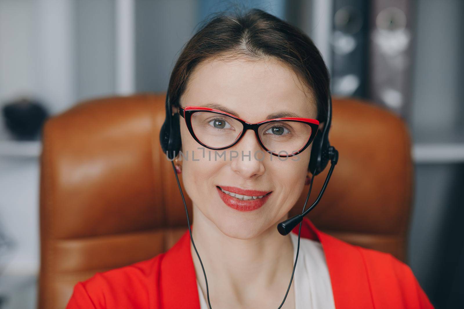 Video chat job interview or distance language course class with online teacher concept. Happy young woman wear headset communicating by conference call speak looking at computer at home office.