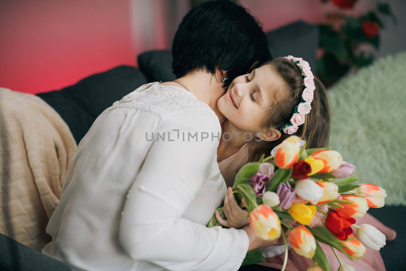 Happy Mother's Day Joy. Kissing and hugging happy family. Beautiful Mother And her little daughter. Smiling Caucasian Senior Mother with her Adult Daughter Hugging and Kisses in Mother's Day. by uflypro