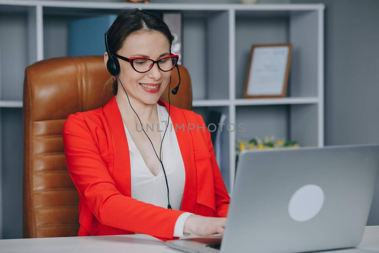 Young woman wears headset conference calling on laptop talks with online teacher studying, working from home. Distance education concept