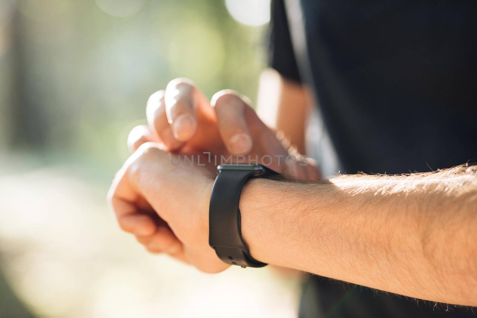 Smart watch. Smart watch on a man's hand outdoor. Man's hand touching a smart watch. by uflypro