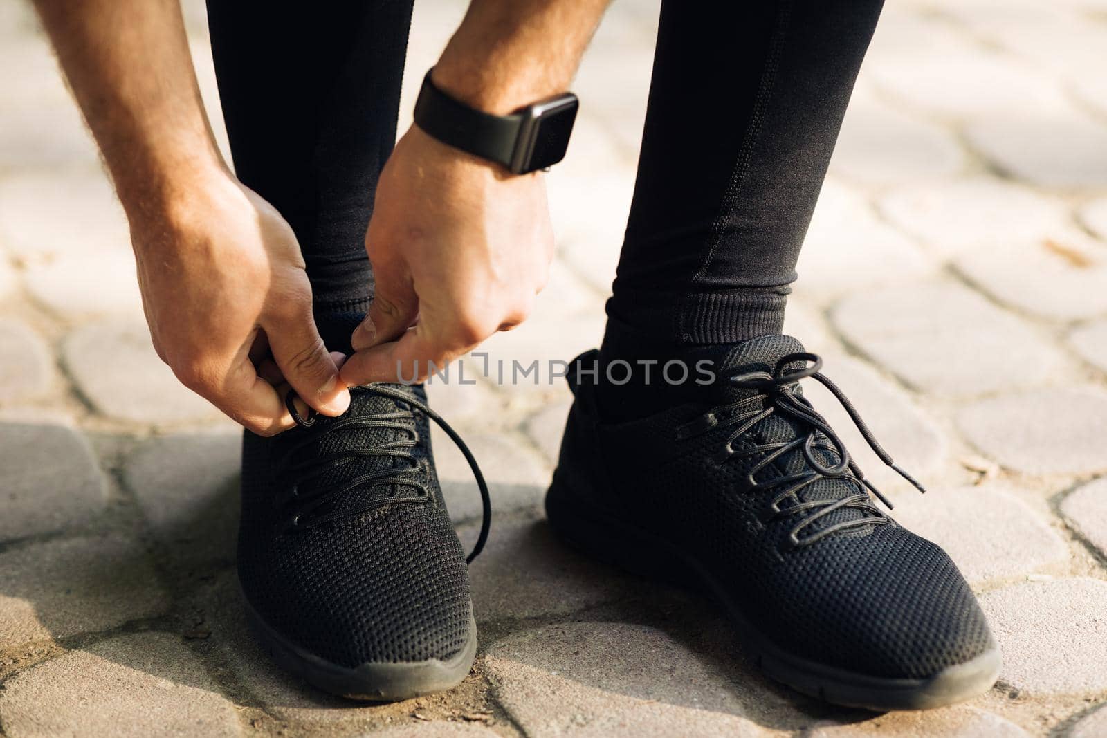 Close up of man tying shoe laces. Male hands tying shoelaces on sport sneakers run workout.