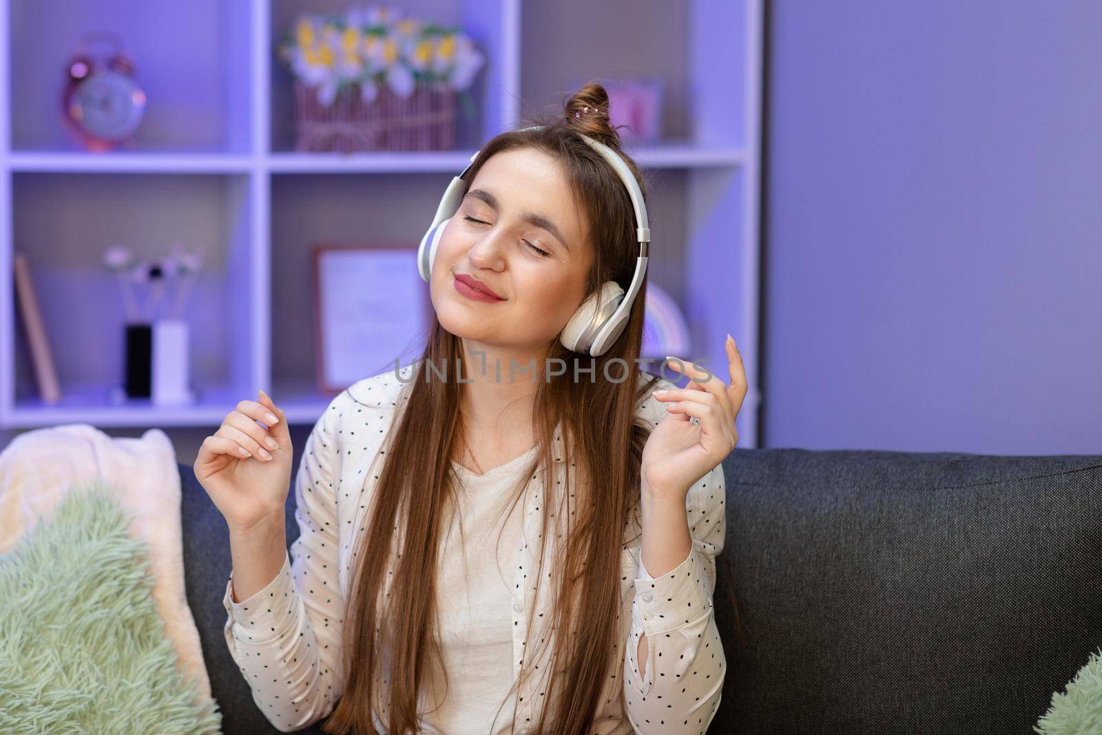 Young beautiful woman in bright outfit enjoying the music at home