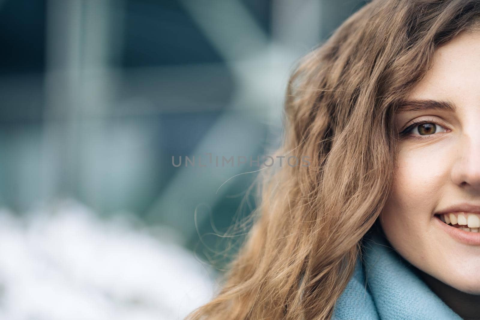 Close up of female half face at street with architecture. Portrait of caucasian woman looking at camera. Pretty curly hair girl outside. Etnnicity. People. Beauty. Happy Young Woman Enjoys Life by uflypro