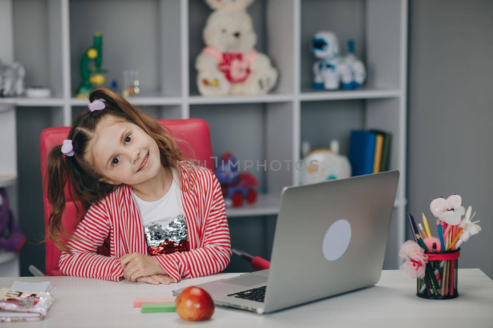 Distance learning online education. Schoolgirl with laptop notebook and doing school homework by uflypro