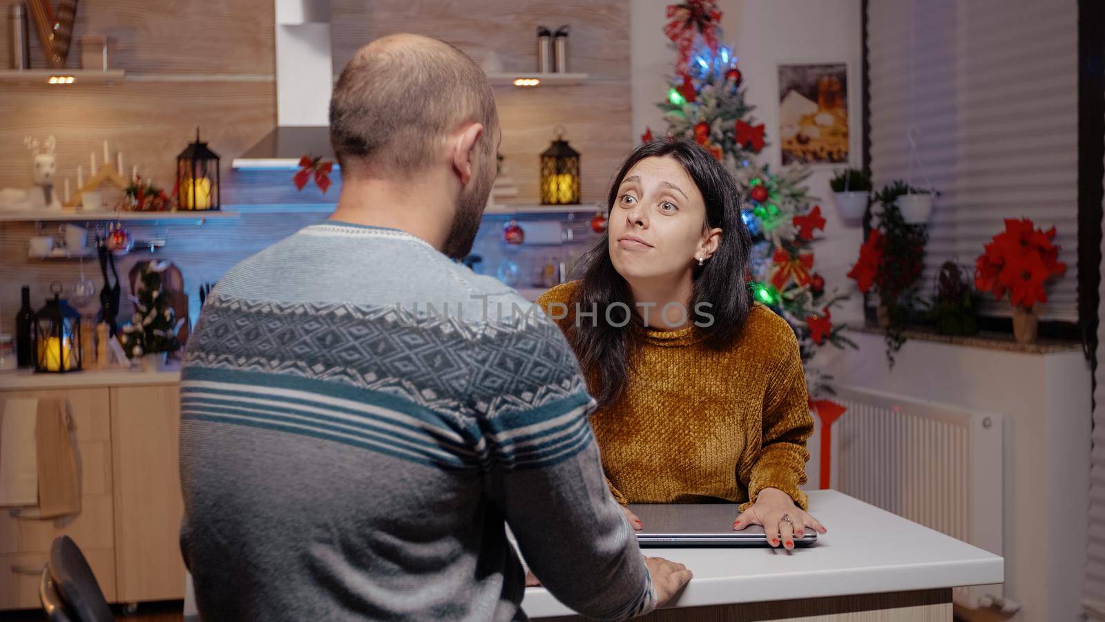 Woman interrupting business video call for man working on christmas eve, to celebrate seasonal holiday. Adult using online conference for work meeting while impatient partner waiting on celebration