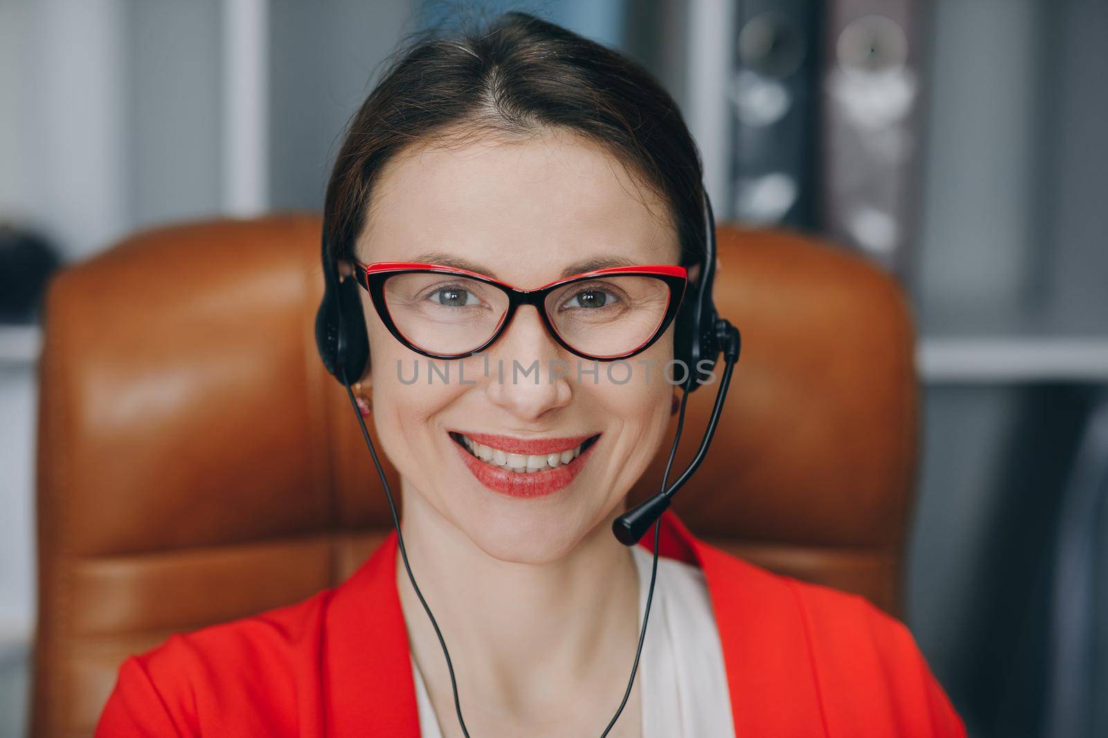 Happy young woman wear headset communicating by conference call speak looking at computer at home office. Video chat job interview or distance language course class with online teacher concept. by uflypro