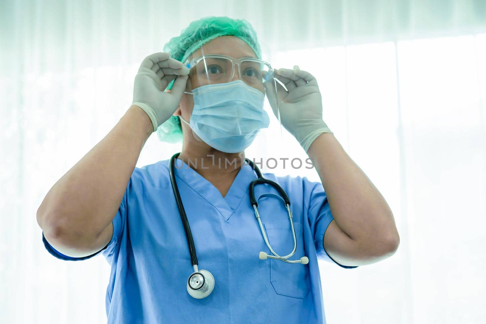 Asian doctor wearing mask, face shield and PPE suit new normal isolated on white background with clipping path to protect safety infection Covid-19 Coronavirus. by pamai