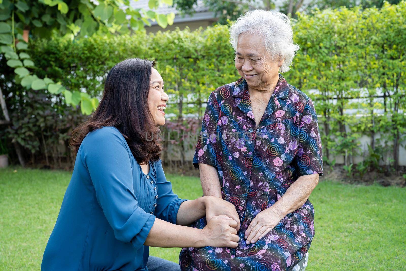 Asian elderly woman with caregiver enjoy and happy in nature park.