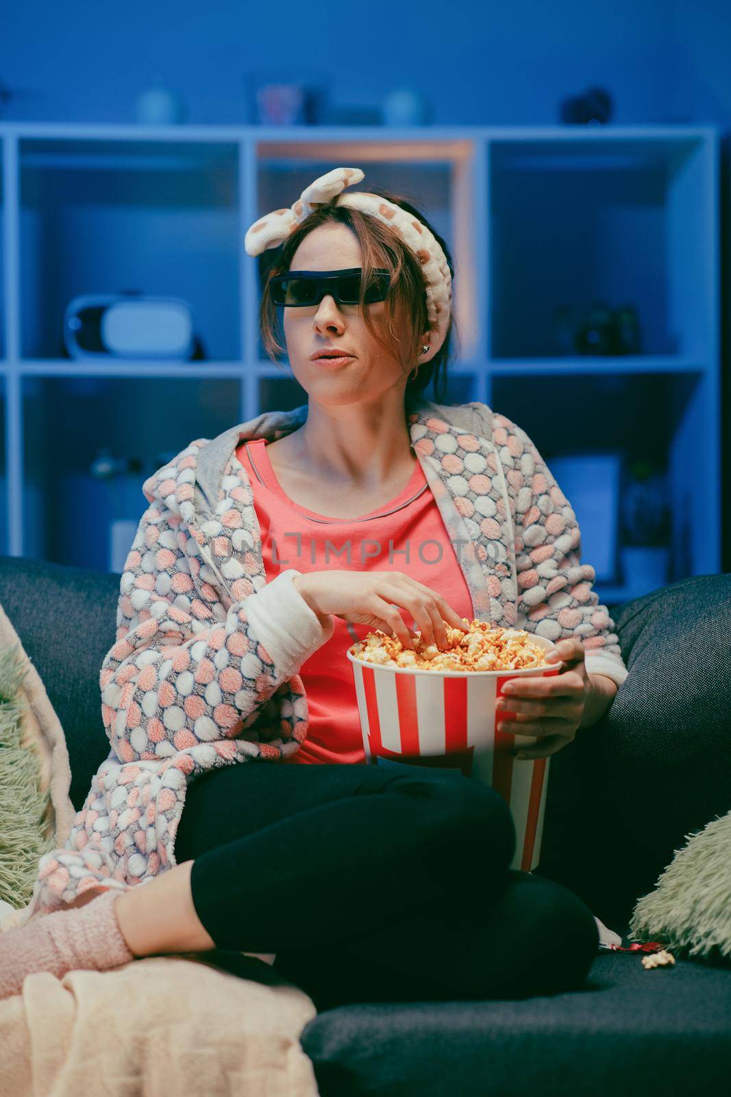 Woman in 3d glasses eating popcorn. Fun young woman in 3d glasses watching movie film, eat popcorn. People sincere emotions in cinema by uflypro