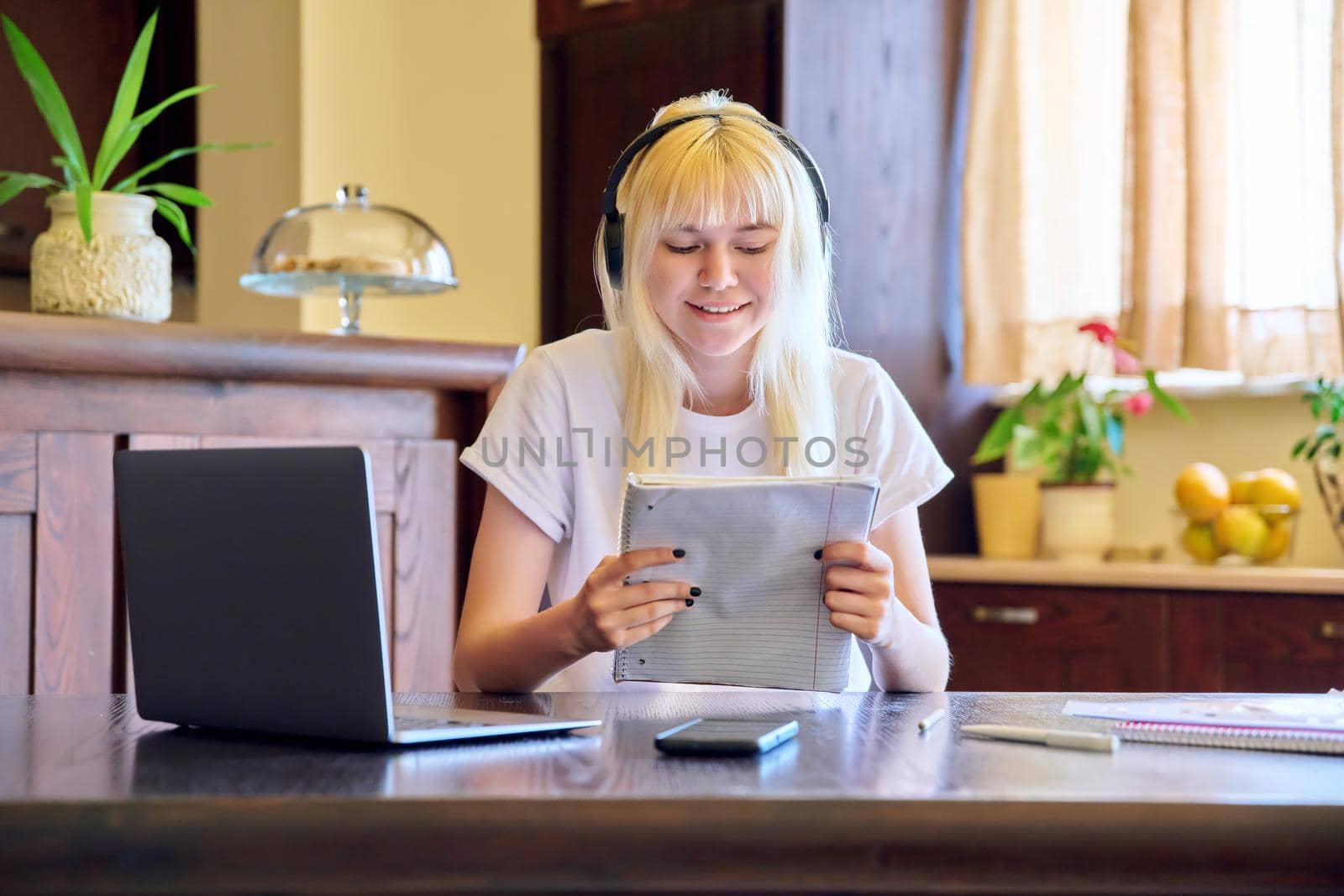 Female student in headphones using a laptop. Teenage girl studying at home, online lessons, video consultation, e-education, self-education, remote classes. Technology in education, teletechnology