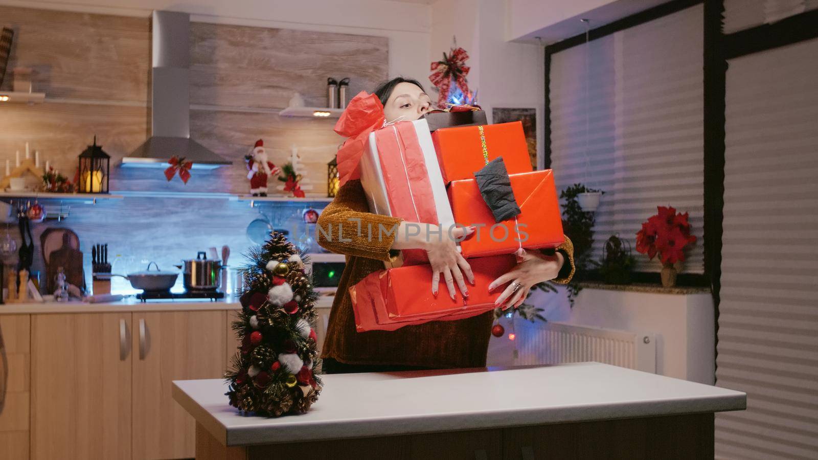 Woman carrying gift boxes for christmas festivity preparations by DCStudio