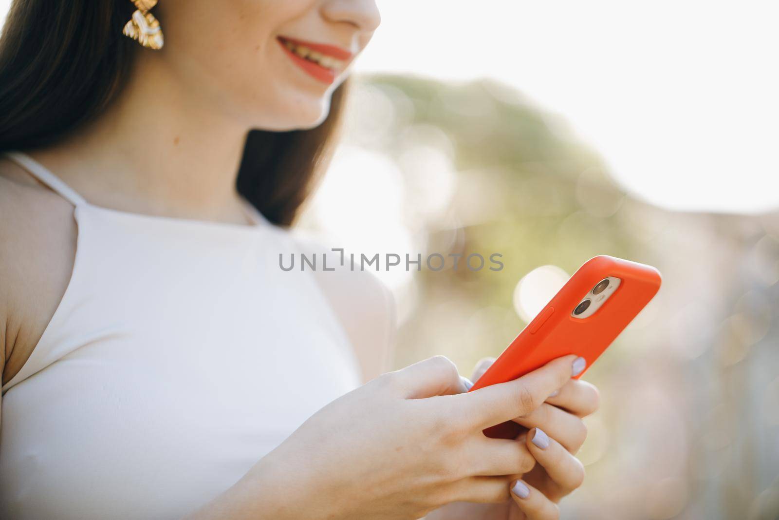 Girl Hands holding smartphone. Woman Using Smartphone in Beautiful Green Park. Technology outdoors. Mockup image of a woman using smart phone at outdoor and green nature background. by uflypro