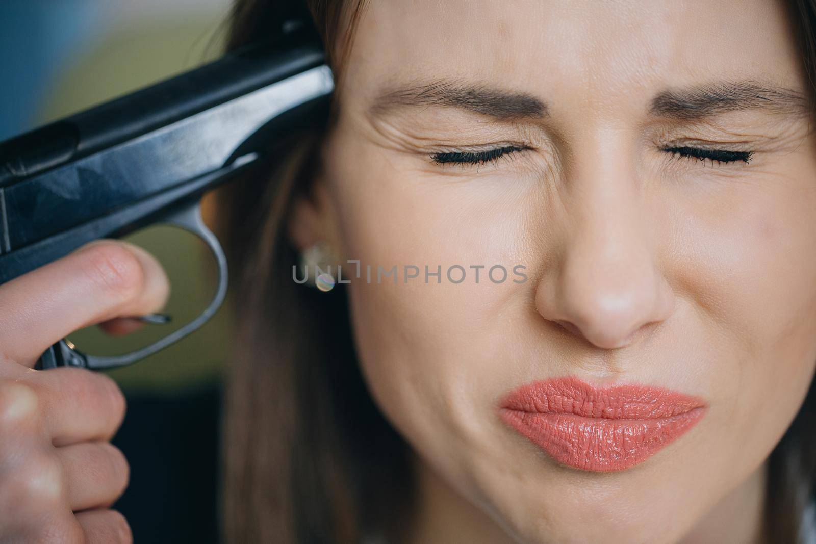 Depression, failure, suicide. Woman making suicide kill herself by gun. A sad depressed woman taking a gun to her temple and trying to kill herself.