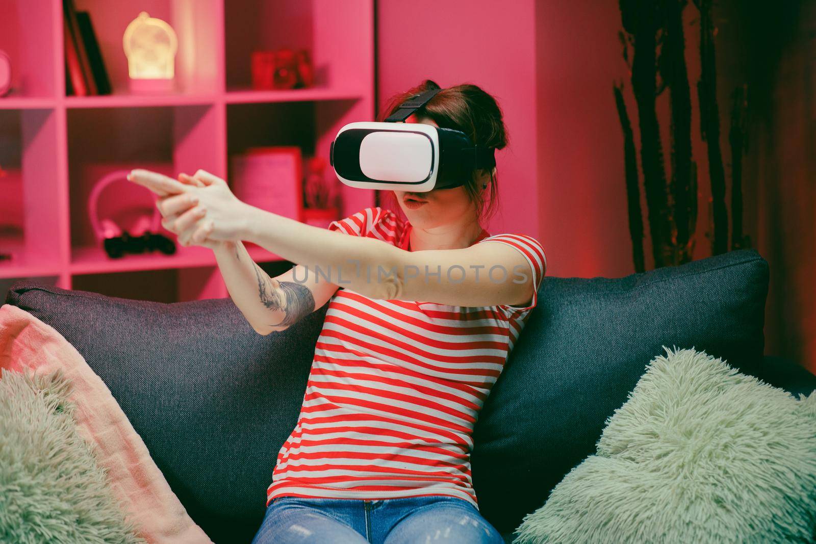 Woman playing and smiling in the VR headset. Virtual reality helmet on color lighting background by uflypro