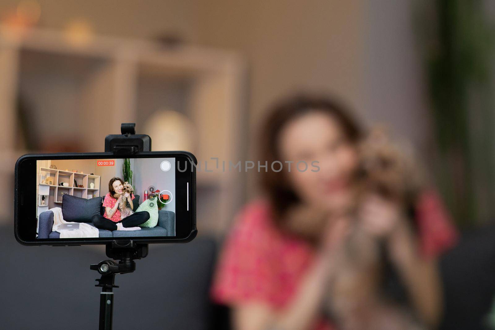 Young woman blogger vlogger influencer sit at home speaking looking at camera talking make video conference call record. Lifestyle blog vlog doing videochat at home concept