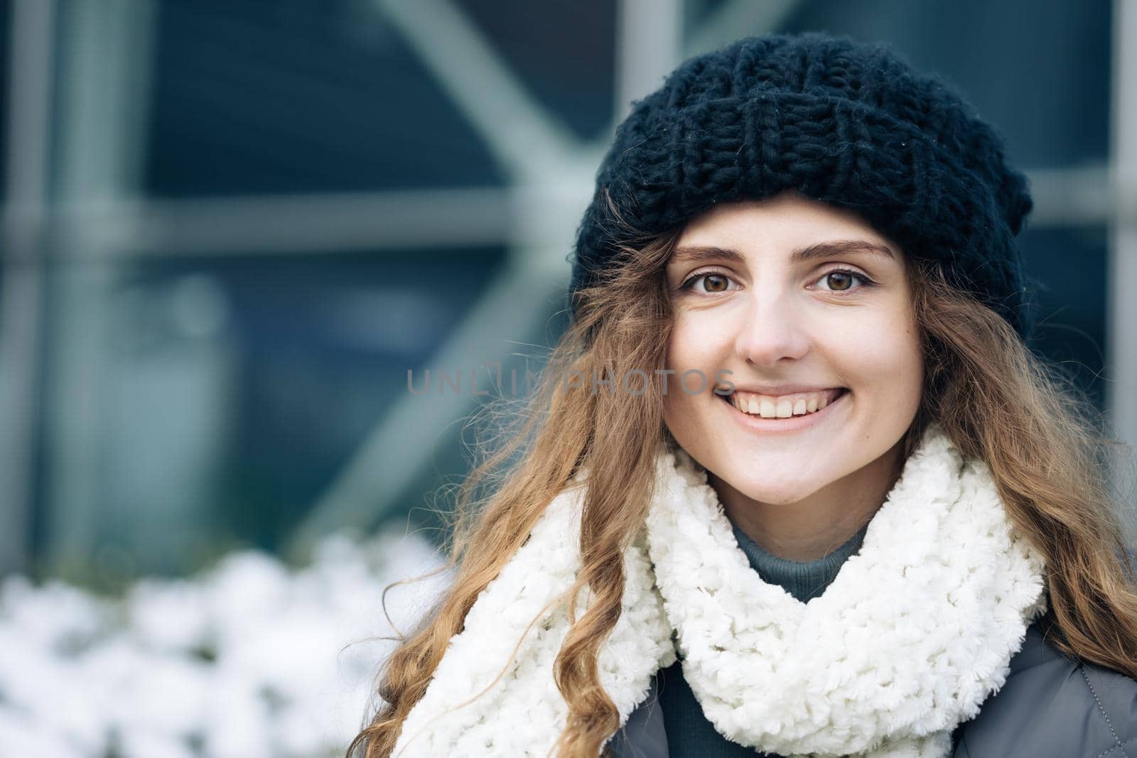 Portrait of a Gorgeous Curly Haired Woman Smiling Charmingly while Standing in the Middle of Modern Urban City Landscape. Happy Young Woman Enjoys Life by uflypro