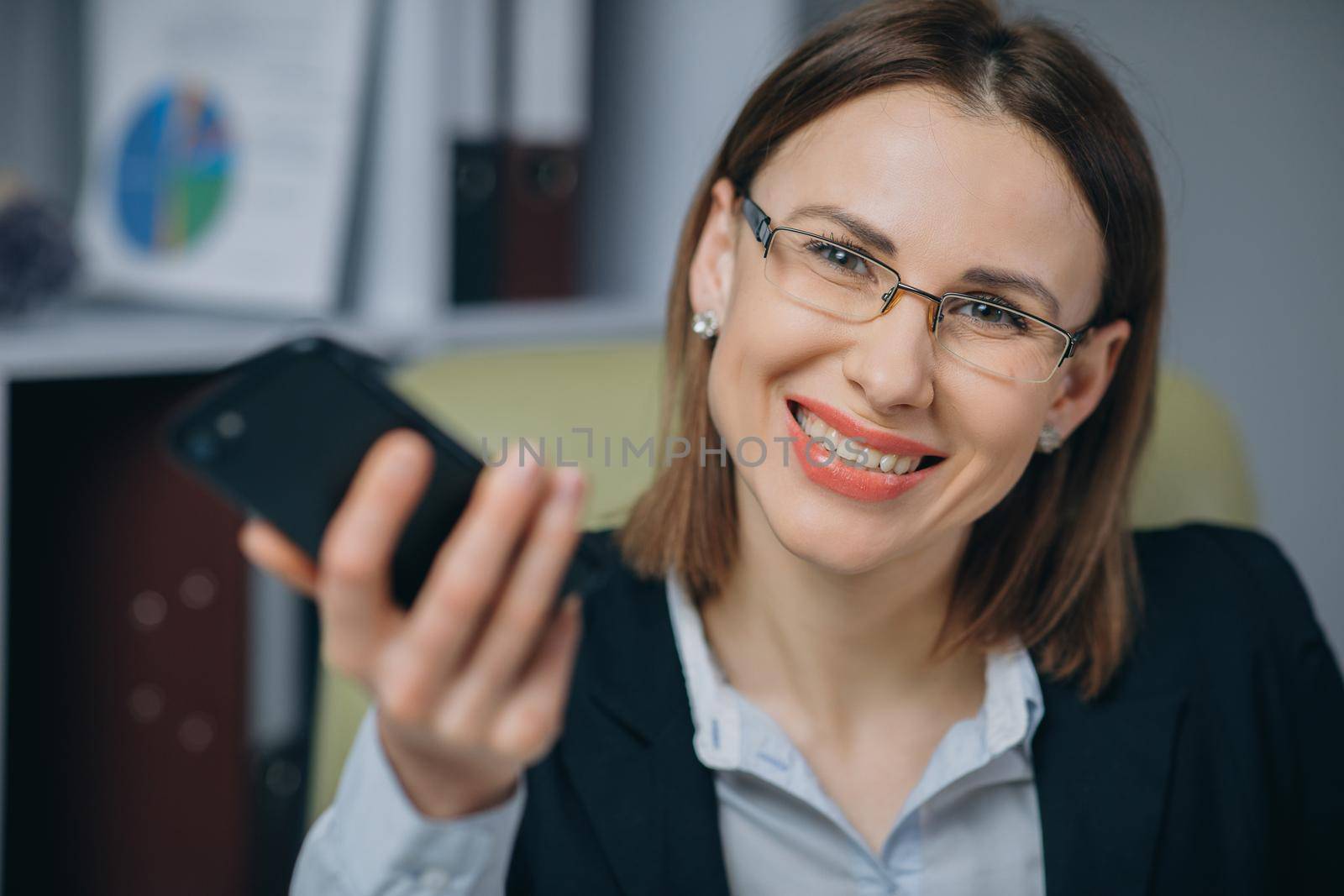 Woman celebrating success in office. Professional female employer receiving good news excited happy cheerful smiling. Success and achievement concept.