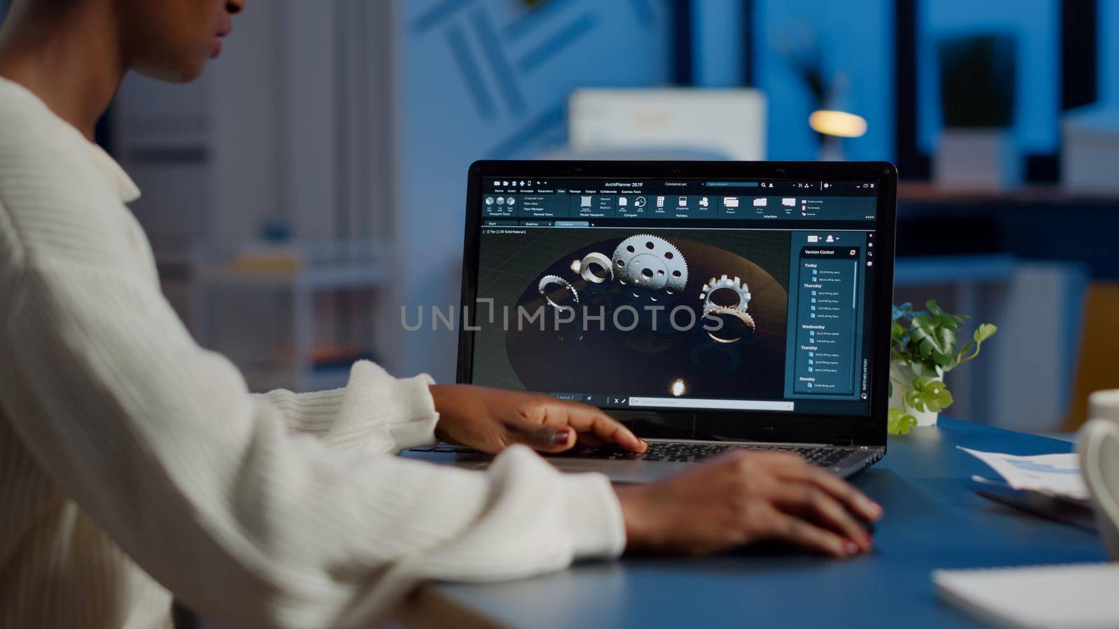 Tired african designer engineer analyzing new prototype of 3D model of industry product, working overtime. Industrial female worker studying gears idea on laptop showing cad software on device display