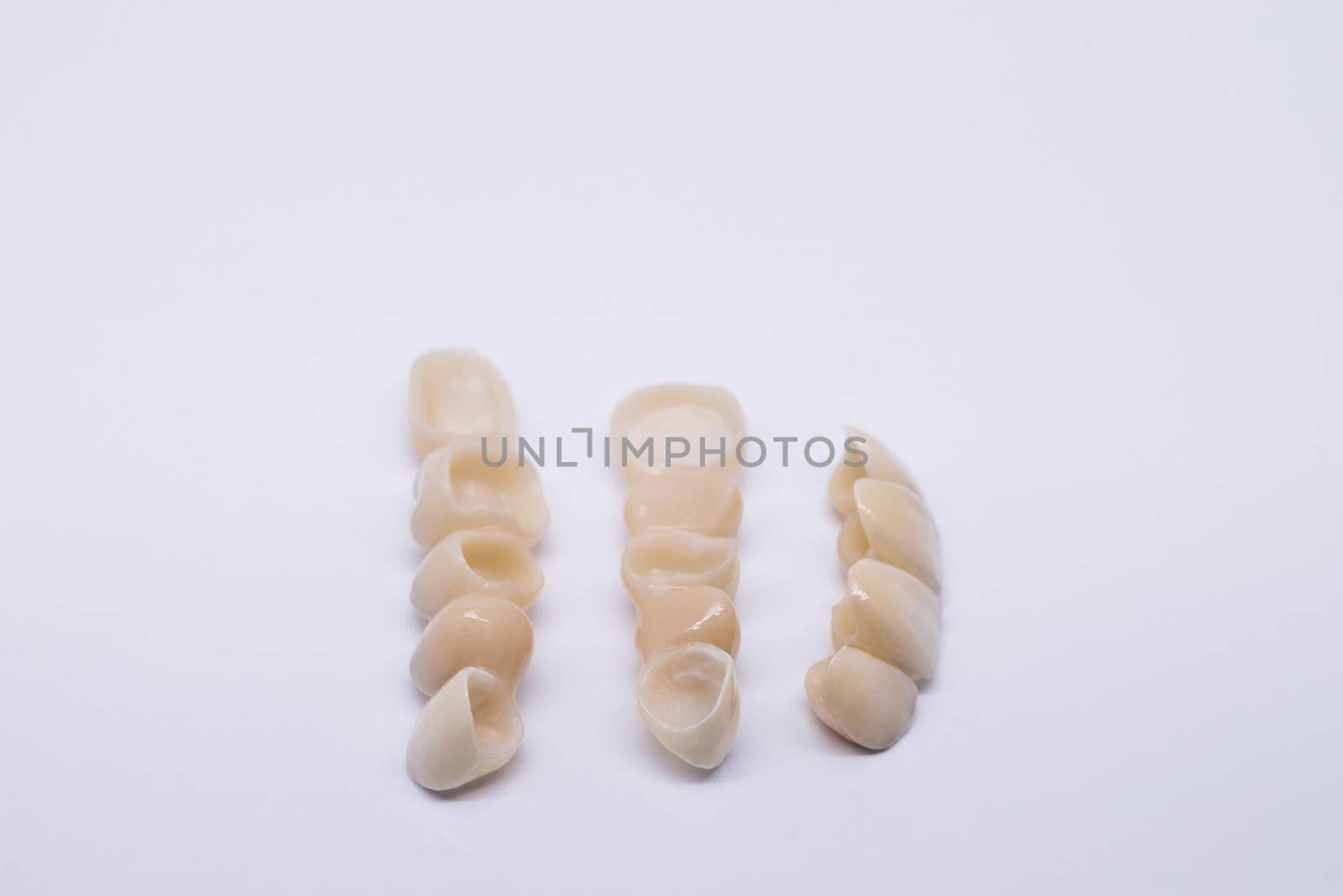 Metal Free Ceramic Dental Crowns. Zirconium tooth crown isolate on wite background. Aesthetic restoration of tooth loss. Ceramic zirconium in final version.