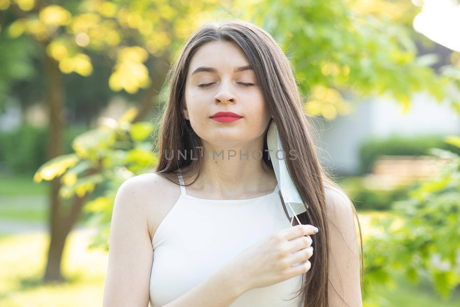 Portrait of a young woman wearing protective mask on street crowd people. Concept health and safety, N1H1 coronavirus quarantine, virus protection.