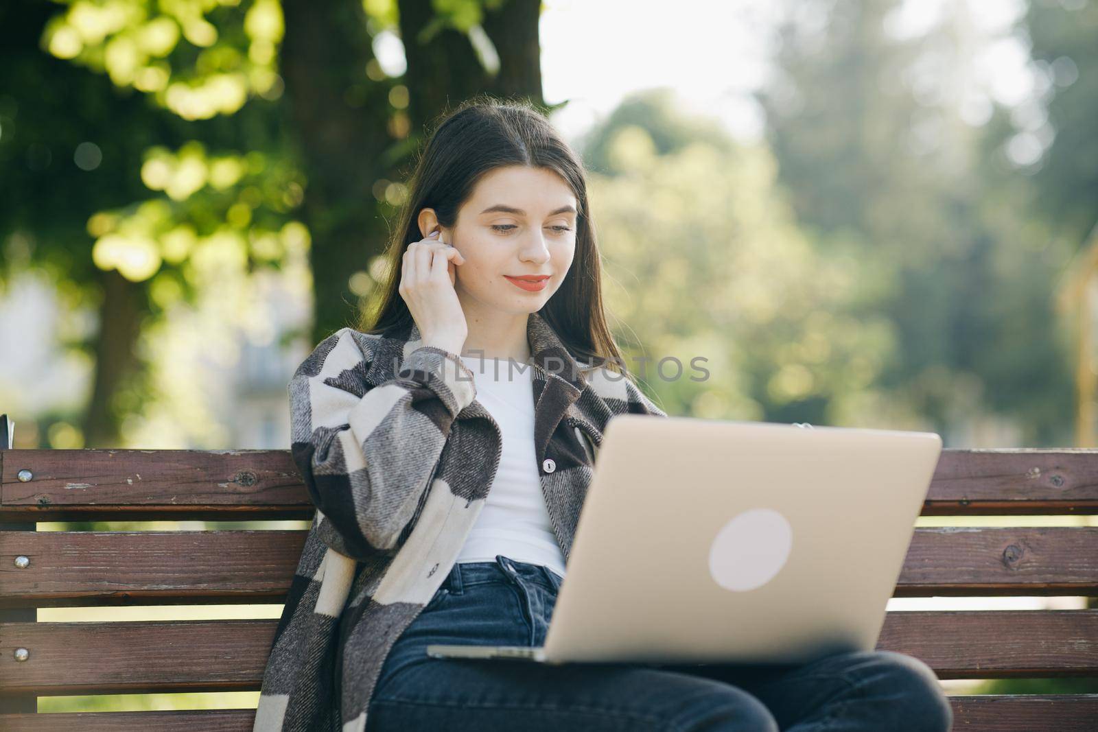 Young student watching lesson online and studying from park. College university student using laptop computer. Studying working with pc technology online education concept