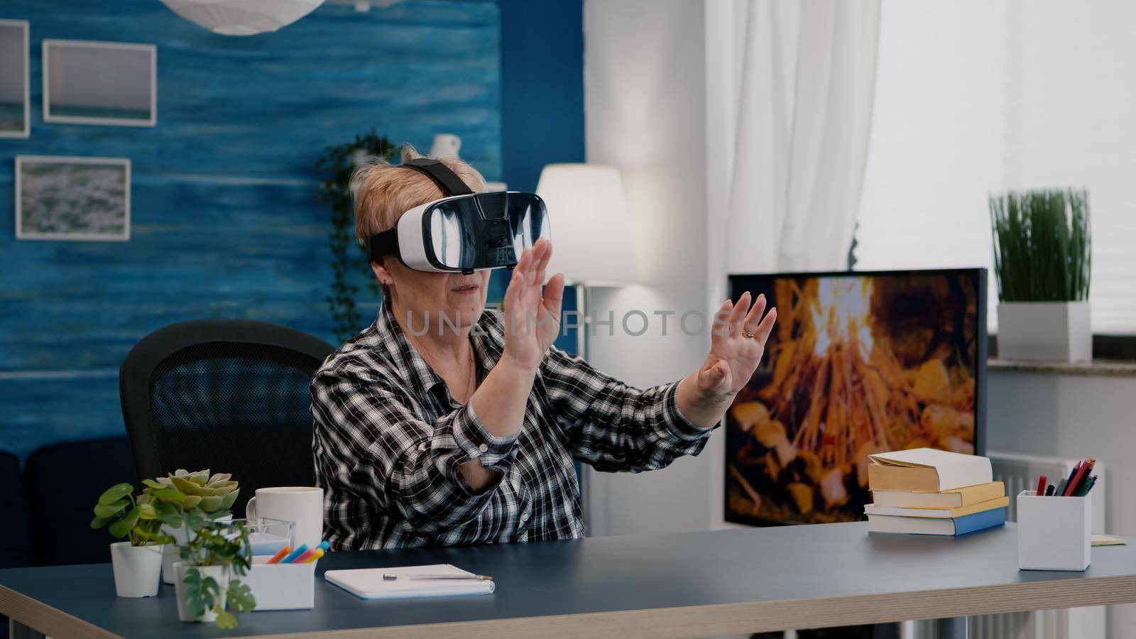 Retired woman experiencing virtual reality using vr headset at home by DCStudio
