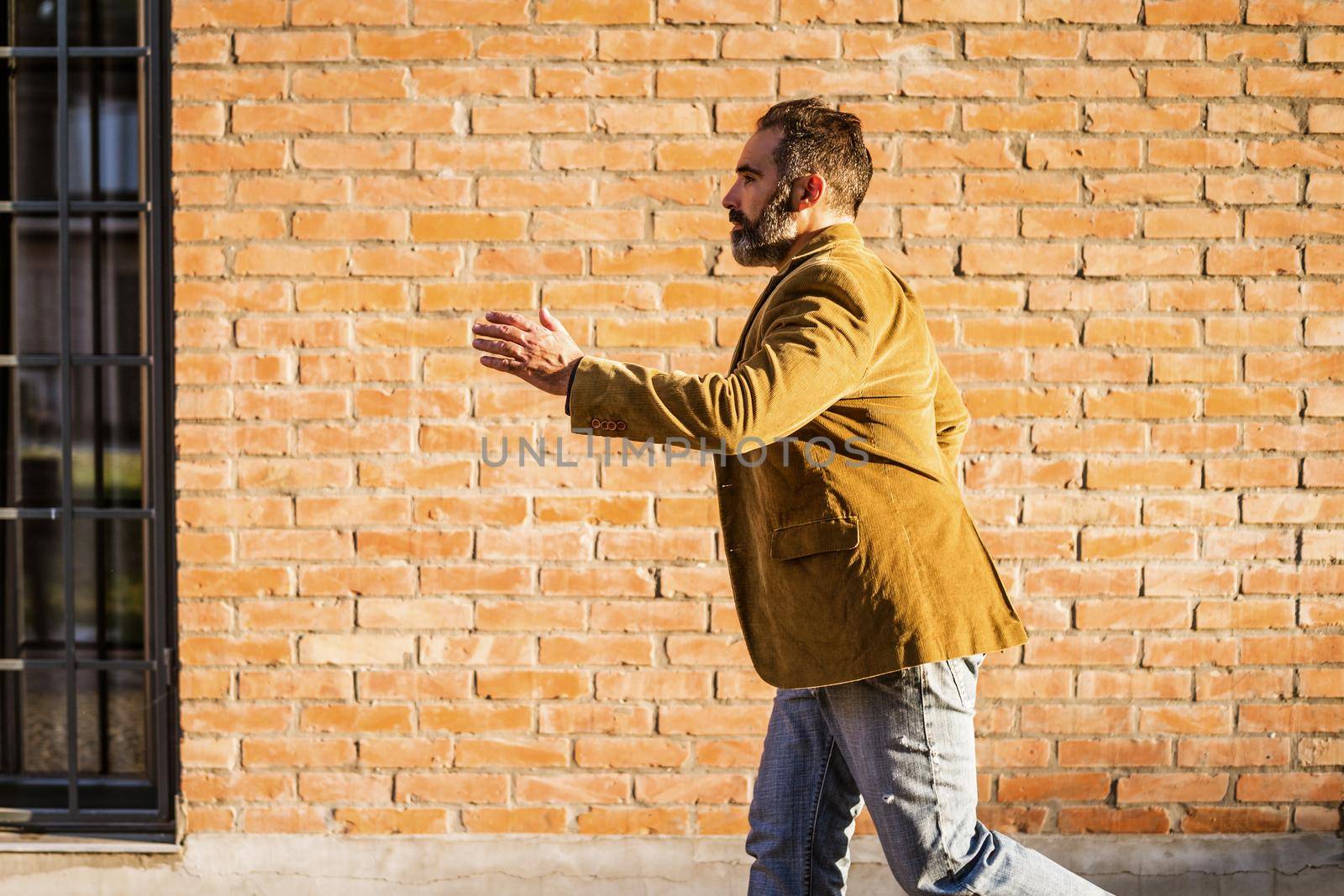 Modern businessman with beard running in a hurry on the street.