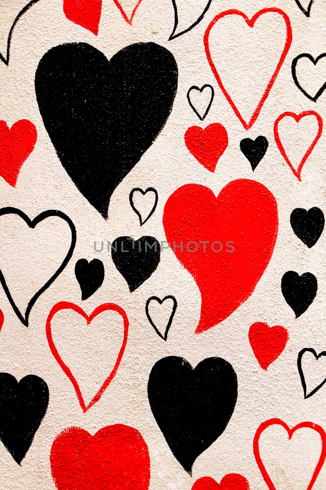 Black, white and red hearts painted on white wall in Spain