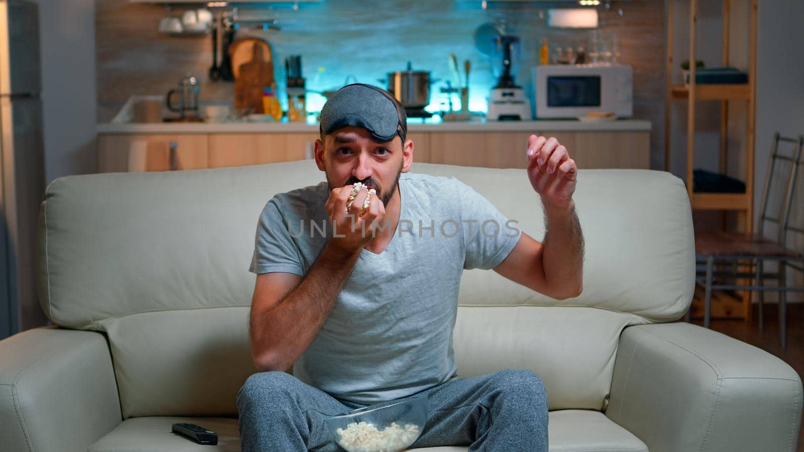 Big soccer football sport fan watching championship game, series finale, expressing anger dissapointment, favourite team loosing watching TV in living room. Throwing popcorn in anger dissapointment and frustration