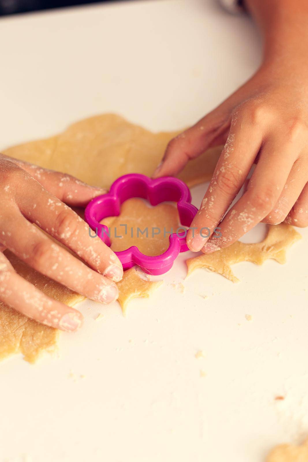 Granchild using shape cutter for dough on christmas day by DCStudio