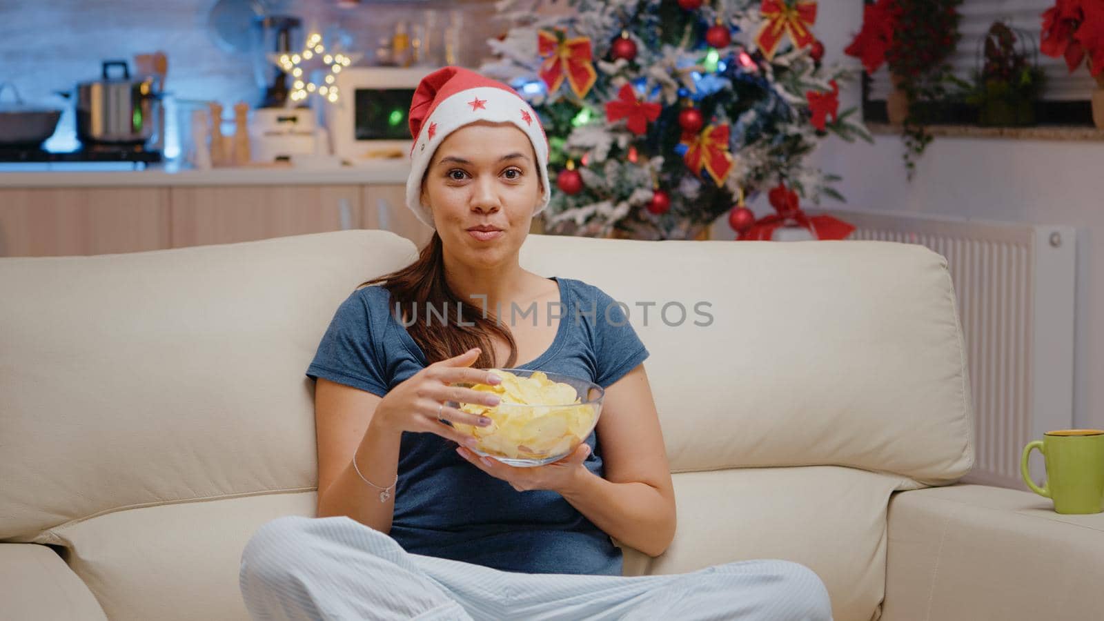 POV of woman using video call communication and eating chips by DCStudio
