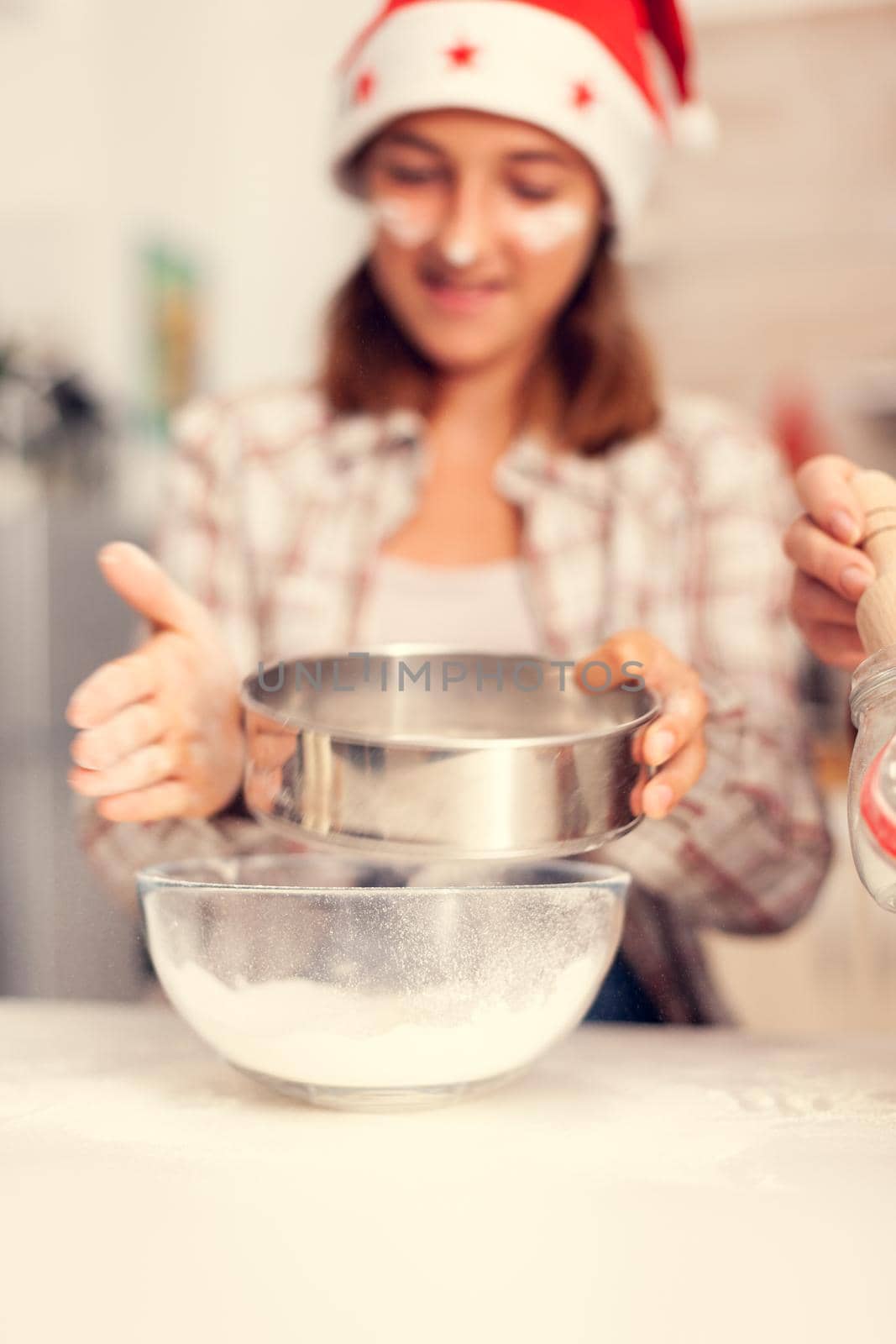 Grandchild on christmas day sifting flour for cookies by DCStudio