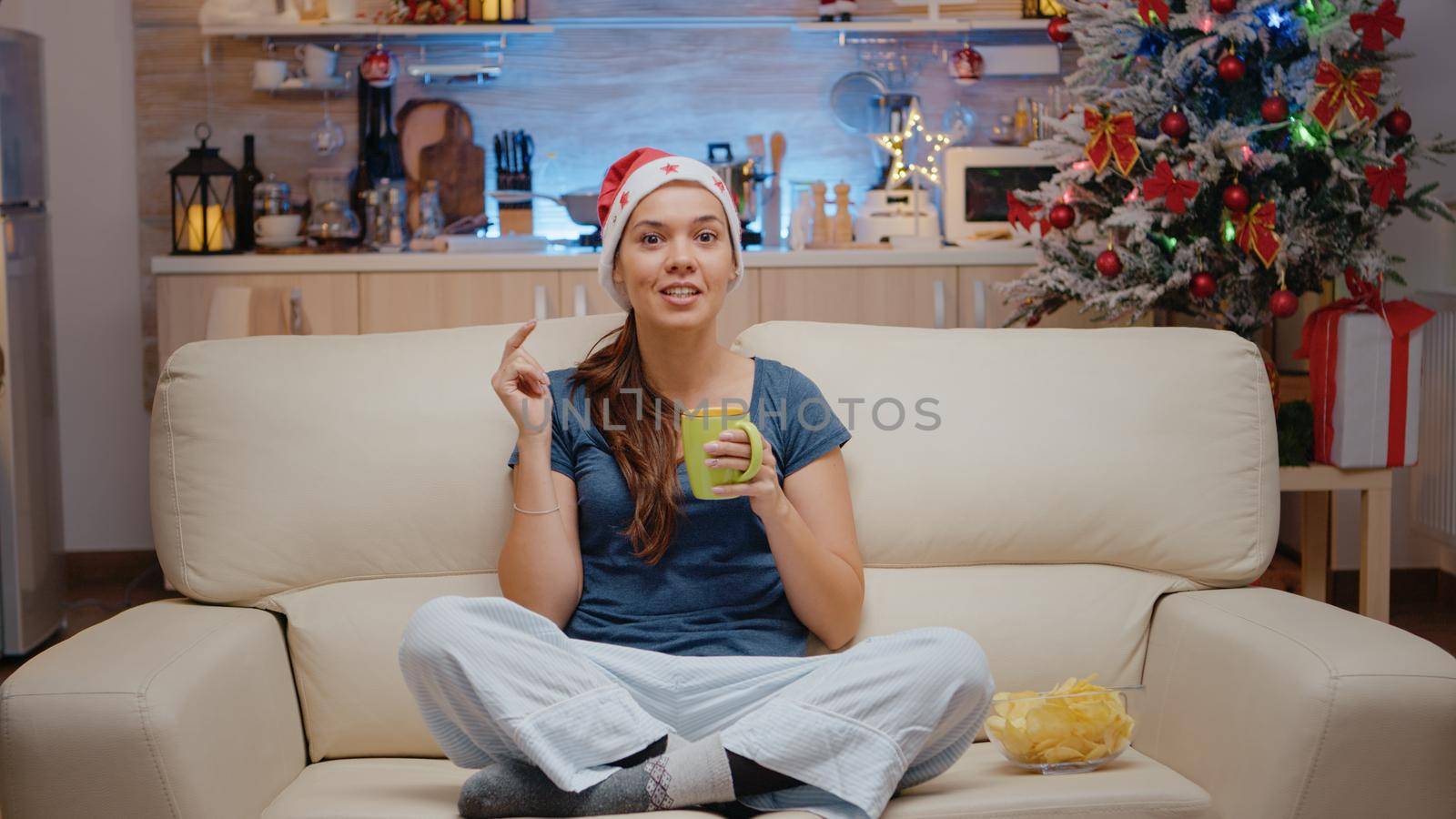 POV of festive woman talking on video call with family on christmas eve. Person using online conference on internet for remote holiday celebration while looking at camera and chatting