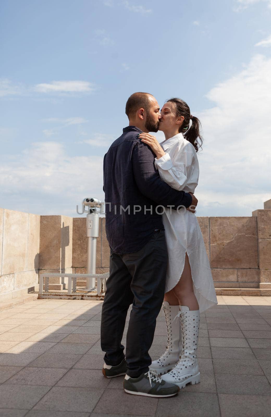 Married lovers kissing on tower terrace celebrating relationship anniversary enjoying seeing panoramic view of metropolitan city. Beautiful landscape view from observation point