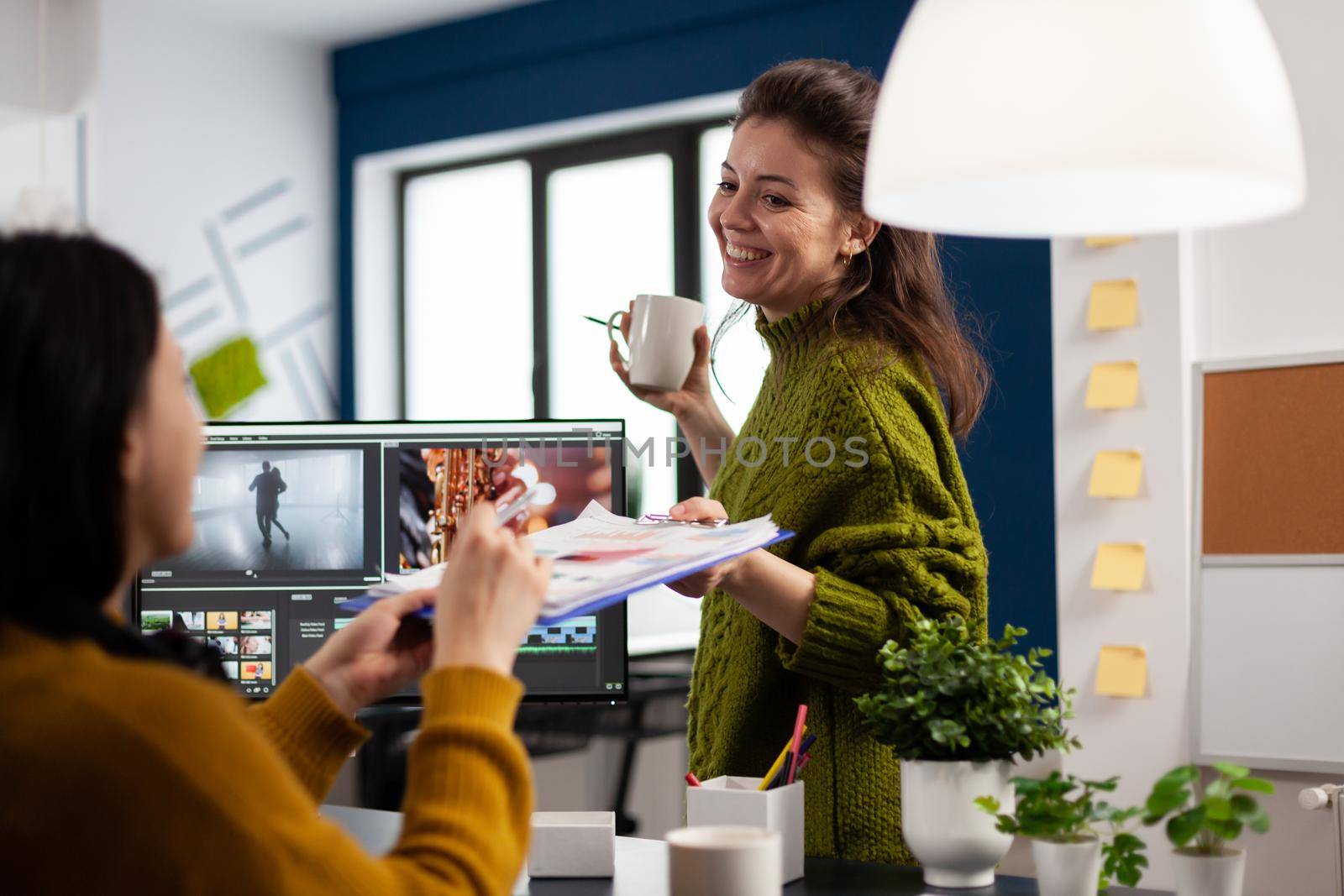 Editor colleagues working in strat up creative workplace using post production software developing film design of digital project. Video editor and sound engineer prosessing movie footage montage