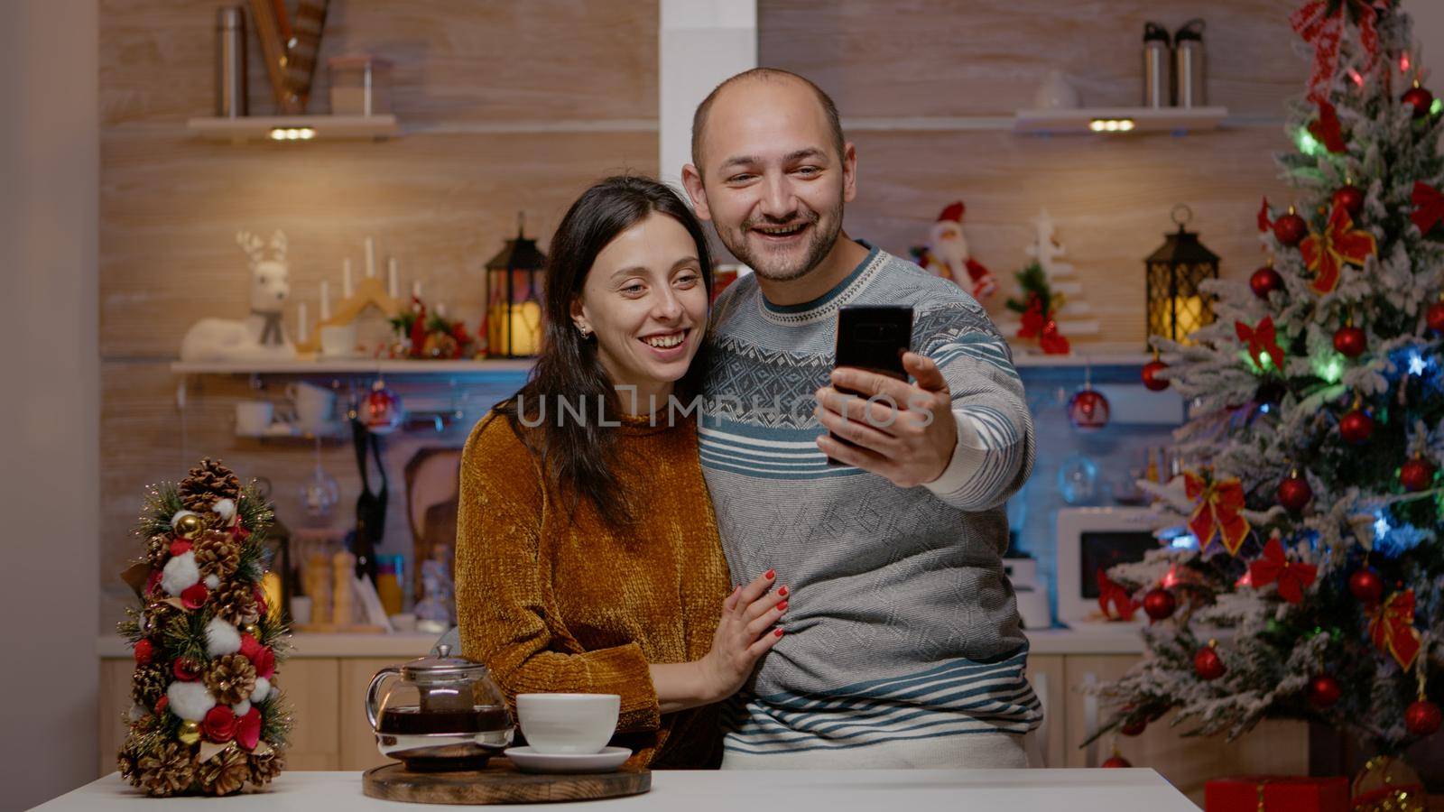 Cheerful couple using video call communication on smartphone by DCStudio